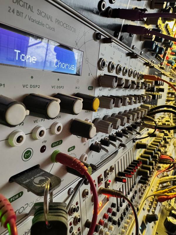 Close-up of modular synth patch cables and a DSP module