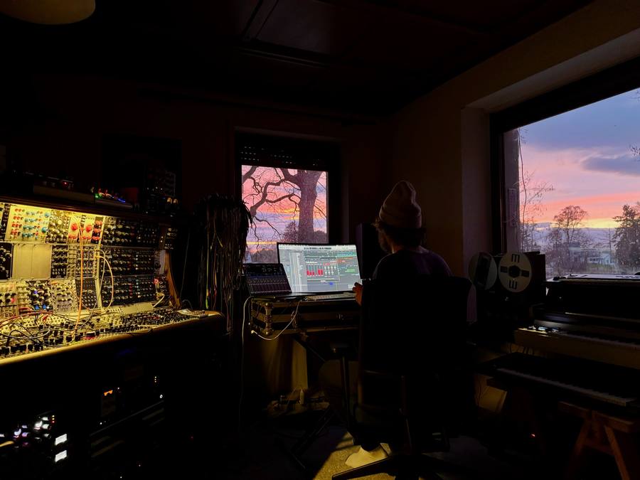 Producer at the desk, sunset burning through the studio windows