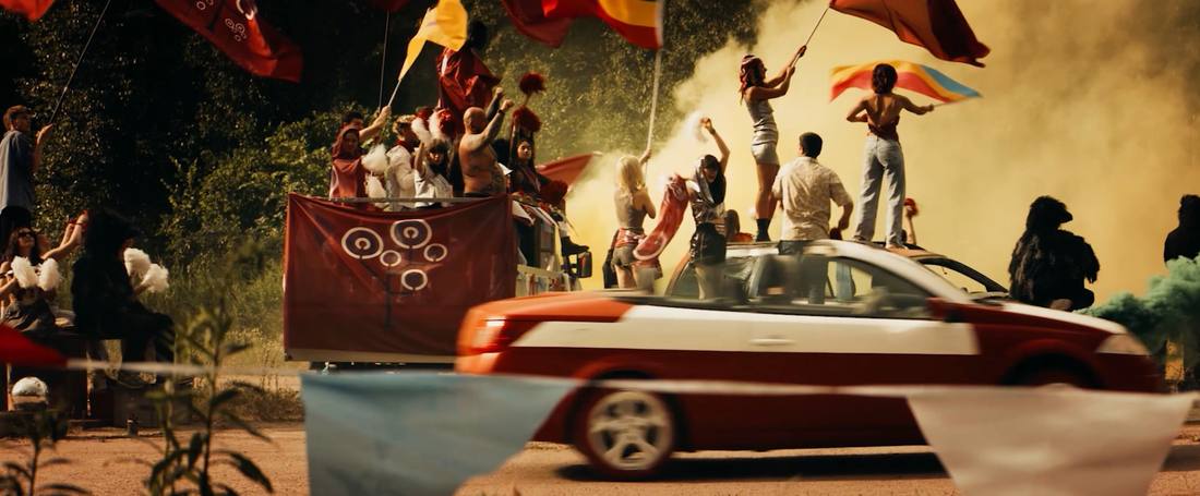 Crowd with flags and smoke on cars and a truck