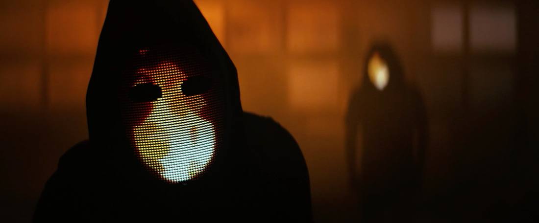 Close-up of a pixel LED mask glowing in orange light